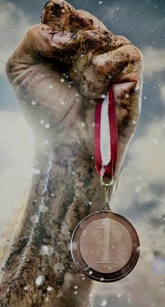 a close up of a person holding a medal