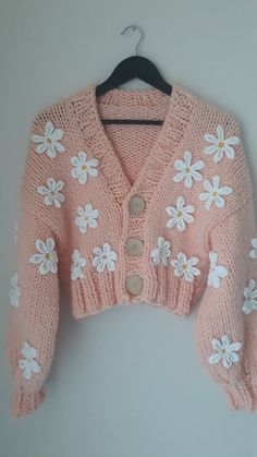 a pink sweater with white flowers on it