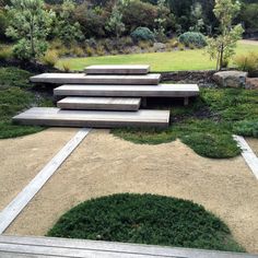 a set of concrete steps sitting in the middle of a grass covered field with trees and bushes behind them