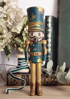 a nutcracker figurine sitting on top of a table next to books