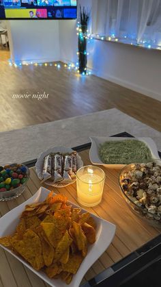 an assortment of food on a table with a television in the background