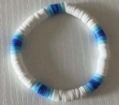 a white and blue bracelet on top of a table