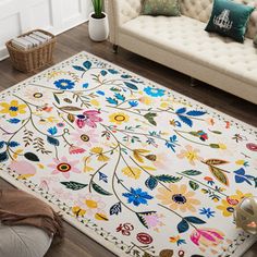 a white rug with colorful flowers on it in a living room next to a couch