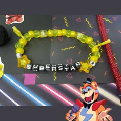 a bracelet with the word superstar written on it next to some toys and other items