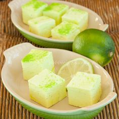 two plates with pieces of cake on them and limes in the backgroung