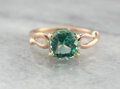 This is a beautiful vintage ring, a solitaire that is as lovely as it is versatile! Simple sweeps of gold grace the shoulders, providing a perfect balance to the gorgeous center stone! We've set a Colombian Emerald in this ring, a bright green gem with unbelievable shine! Incredibly clear and filled with light, this emerald is of exceptional quality, a one of a kind stone from our collection of Colombian gems that we're proud to offer! Metal: 14K Yellow and Rose Gold Gem: Emerald 1.56 Carat Gem Classic Solitaire Diamond Ring For May Birthstone, Classic Solitaire Emerald Promise Ring, Elegant Solitaire Diamond Ring For May Birthstone, Elegant Emerald Ring With Round Band For Promise, Elegant Green Sapphire Ring With Center Stone, Classic Emerald Ring With Accent Stones, Classic Emerald Ring With Accent Stones And Round Band, Classic Rose Gold Emerald Ring With Prong Setting, Elegant Emerald Ring With Round Stone For Anniversary