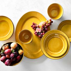 yellow plates and bowls with fruit in them