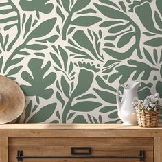 the wallpaper is green and white with leaves on it, as well as a vase