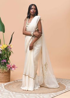 Editor's Note Featuring an ivory sari made in organza fabric crafted with ruffle & trim detail at the edge Note: Blouse worn is for styling purposes only Color: Ivory Fabric: Organza and cotton mesh Occasion: Festive Components: Sari Disclaimer: Product color may slightly vary due to photographic lighting sources or your monitor setting. Care: Dry Clean Only About the Designer Rishi & Vibhuti label combines traditional elements with modern aesthetic uniquely to create chic occasion wear for wome Traditional Cotton Silk Pre-draped Saree With Embroidered Border, Transitional Pre-draped Cotton Silk Saree With Embroidered Border, Festive Off-white Embroidered Sharara, White Organza Pre-draped Saree For Eid, Celebration White Pre-draped Saree With Dupatta, White Pre-draped Cotton Silk Saree With Resham Embroidery, Designer Pre-draped Off White Saree With Sheer Dupatta, Festive Off-white Chanderi Pre-draped Saree, Festive White Organza Pre-draped Saree