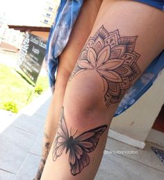 a woman's leg with a butterfly tattoo on it and a flower in the middle