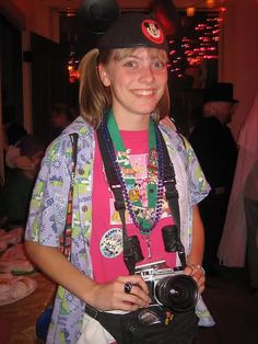 a young woman wearing a mickey mouse hat and holding a camera