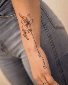 a woman's arm with a flower tattoo on it