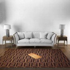 a white couch sitting on top of a wooden floor next to two tables and lamps