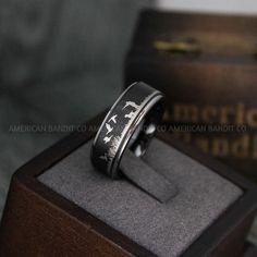 an engraved ring sits on top of a wooden box