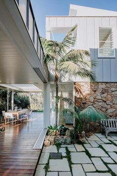 an outdoor patio with stone walls and palm trees