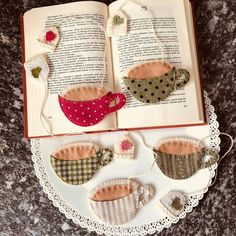 an open book sitting on top of a table next to some crafting items and a lace doily