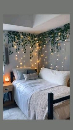 a bedroom decorated with lights and greenery on the wall, along with a bed