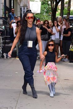 the mother and daughter are walking down the street