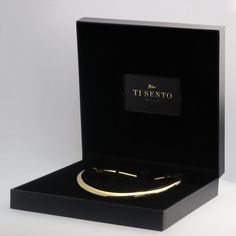 a black box with a gold bracelet in it