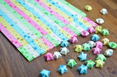 colorful paper stars are scattered on a wooden table