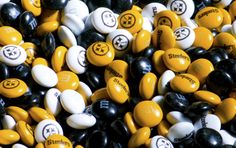 many different colored and black and white candies with smiley faces on them, all together