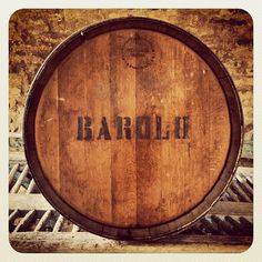 a barrel sitting on top of a wooden table next to a brick wall with the word bardo written on it