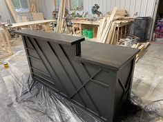 an unfinished bar in the process of being painted with black paint and some plastic wrap around it