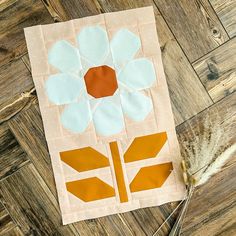 a piece of fabric with a flower on it sitting on top of a wooden floor