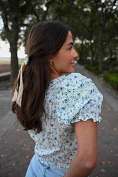 Meet me in the Fields Of Happy, ‘cause I’ve found the top of my dreams! Our newest blue floral print top is perfect for those easygoing spring days. This sweetly-seductive top features a sweetheart neckline, micro-ruffle edges and romantic puffed sleeves with elastic trim. Super cute blue floral print Micro-ruffle smocked sweetheart neckline Three layers of string ties with upside down v hemline Quality material (to avoid any see-through) Available in S,M,L. Model is 5’6 and wearing a size small Spring Garden Party Tops With Puff Sleeves, Spring Garden Party Puff Sleeve Tops, Ditsy Floral Print Short Sleeve Tops For Garden Party, Short Sleeve Ditsy Floral Tops For Garden Party, Summer Top With Smocked Bodice For Garden Party, Summer Garden Party Top With Smocked Bodice, Spring Ditsy Floral Print Tops For Garden Party, Spring Tops With Ditsy Floral Print For Garden Party, V-neck Ruffle Top For Garden Party