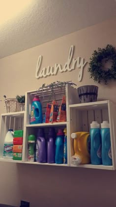 a white shelf filled with lots of cleaning supplies next to a sign that says laundry