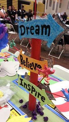 a table topped with lots of paper cut outs and signs that say dream, believe, inspire