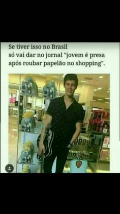 a man holding a skateboard standing in front of a store window with an ad on it