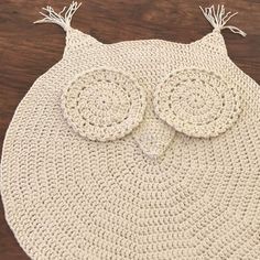 a crocheted owl rug is shown on a wooden floor with the eyes closed