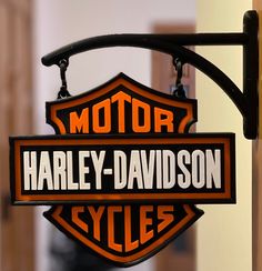 a harley davidson sign hanging from the side of a building