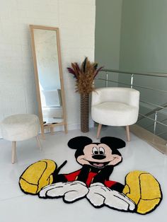 a mickey mouse rug in the middle of a living room with a mirror and chair