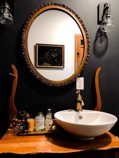 a bathroom sink sitting under a round mirror