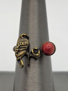 This is a beautiful Native American style bypass ring in brass.  ATTRIBUTES - Unsigned, but appears artisan made in Native American style - Brass - non magnetic  - Features a bird (falcon?) with a flower and red stone which appears to be dyed howlite, a semiprecious gemstone  - Ornate twist on each side - Lovely condition with minor wear from gentle use  MEASUREMENTS - Size 6 3/4 on the mandrel - Main portion measures 0.70" wide x 0.60" tall at the bird CONDITION - Excellent GENTLY USED conditio Adjustable Red Nature-inspired Jewelry, Artisan Jewelry Handmade, American Pattern, Native American Style, Jewelry Beautiful, Bypass Ring, Pattern Glass, Native American Fashion, Red Stone