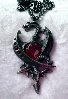 An accursed black dragon, with the heart of a diamond; a metaphor for a dangerous relationship, or else a powerful ally? Set with 11 Swarovski crystals. Made by Kiss of a red rose with inspiration from Alchemy England. The pendant comes with a red velvet gift pouch. Black And Red Dragon, House Targaryen Aesthetic, Red Outfits, Targaryen Aesthetic, Reality Shifting, Dragon Jewelry, House Targaryen, Rose Rouge, Heart Pendant Diamond