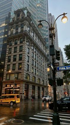 an intersection in the middle of a city with tall buildings and street lights on either side