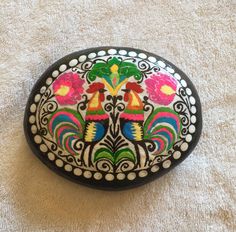 a colorful painted rock sitting on top of a white carpet