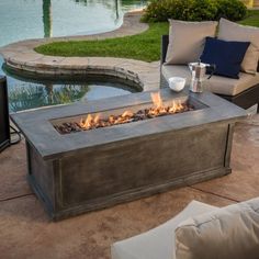 a fire pit sitting on top of a patio next to a swimming pool