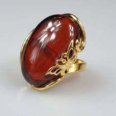 Amber ring. Chery - ruby red Amber. Gold plated ring. This ring is adjustable. You can change size by pressing it. Very easy to do. Stunning red ring will be just the best gift for Christmas. Gemstone size 3 × 2 cm. Weight 8,70 gr. This item was made of natural Baltic Amber. All the amber used in my jewelry is collected in my home country Lithuania. I sell only genuine, real, not pressed, authentic, natural Baltic Amber. Item may have natural imperfections. Due to amber being natural, each of my