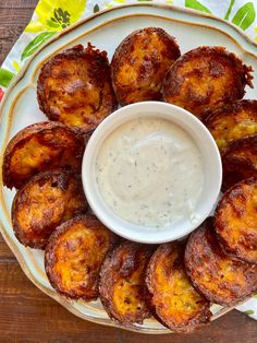 a white plate topped with fried potatoes and dip