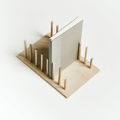 a wooden structure with several pegs sticking out of it's sides on a white background