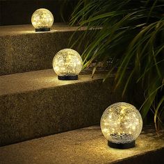 three solar powered balls sitting on steps