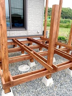 a wooden structure sitting on top of gravel next to a building