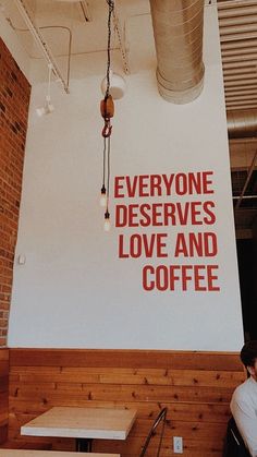 there is a sign that says everyone deserves love and coffee on the wall in this restaurant