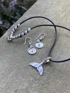 Description Bring out your inner Mermaid with this jewelry that can be purchased individually or as a set. This necklace and earring set is part of The New England Collection and represents the state of Massachusetts. The necklace features a hypoallergenic artisan pewter whale or mermaid tail hung on high quality leather that is US sourced and free of AZO and formaldehyde. The unique swirl clasp is artisan pewter as well. Let me know in the message box at checkout if you need a custom length. Th Minimalist Spiral Jewelry With Matching Earrings, Nickel-free Spiral Metal Jewelry, Minimalist Spiral Metal Jewelry, Symbolic Metal Jewelry With Matching Earrings, Minimalist Spiral Nickel-free Jewelry, Minimalist Nickel-free Spiral Jewelry, Symbolic Silver Jewelry With Matching Earrings, Adjustable Spiral Nickel-free Jewelry, Adjustable Sterling Silver Jewelry Sets For Gifts