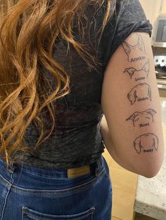 the back of a woman's shoulder with three different tattoos on her left arm