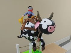 a toy cow with a man on it's back